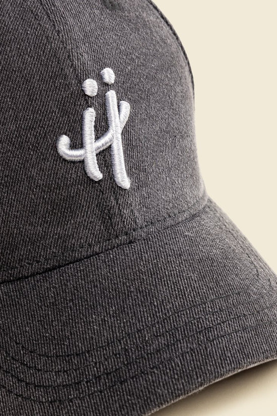 Gray cap with a white logo on a beige background