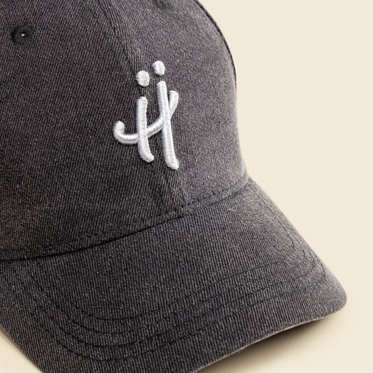 Gray cap with a white logo on a beige background